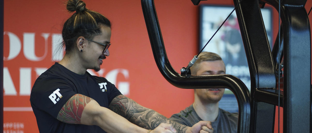 Personal trainer assisting row